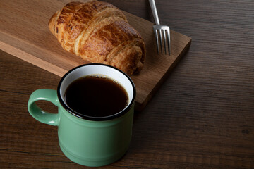 Croissant with a cup of full coffee ,directly above