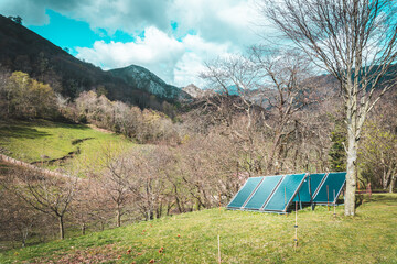 
Solar panels in the garden of a rural house in the middle of the mountain on a sunny day. An...