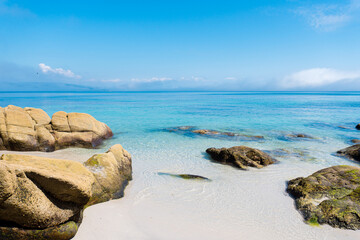 Paradise beach with turquoise waters and calm sea with white sand and small rocks. Ideal for traveling and getting lost. Galicia, Spain
