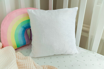White pillow on a bed, baby room mockup.