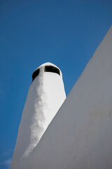 Greek Chimney Isolated. Copy Space. Whitewashed chimney in Syros Island . Blue sky in the background. Stock Image.