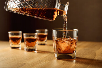 Whiskey is poured into a dammed glass with ice.