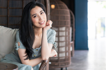 Happy beautiful woman. Young woman with long black hair in a coffee shop during the brunch. Travel and lifestyle. Young girl in cafe. Portrait of beautiful smiling woman in a cafe.