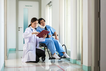 Doctor explaining operation to Patient on wheelchair by the corridor. Female Doctor giving advice to Female Patient. Doctor talking to her patient.