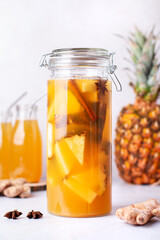 Tepache drink in glass bottles with reusable drinking straws and glass pitcher on kitchen table