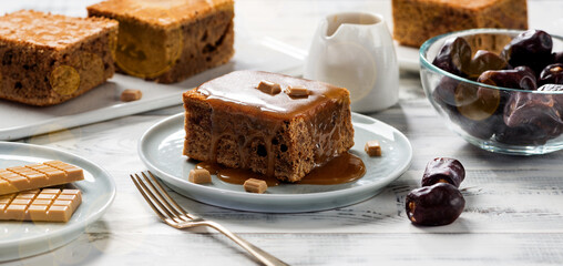 Easy Sticky Toffee Pudding is a deliciously gooey sponge cake drenched in warm toffee sauce that’s a favorite among the English.  - obrazy, fototapety, plakaty