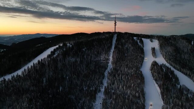 4K Aerial winter sunrise or sunset view of Rhodope Mountains and Snezhanka tower near resort of Pamporovo, Smolyan Region, Bulgaria