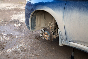 Passenger car with the front wheel removed. Replacement of brake pads.