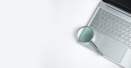 Technology banner with laptop keyboard and magnifying lens with copy space for text. High quality...