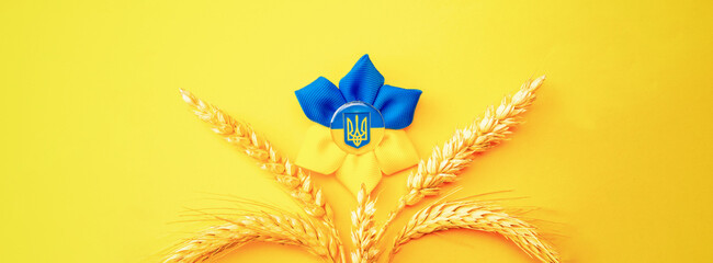 Ukraine symbol yellow background. Ukrainian flower trident symbol with wheat grain ear isolated on...