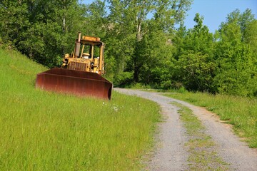 bulldozer abandonné aux abords d'un chemin