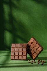 chocolate on green background with grains. Creative chocolate photography. Sweet food