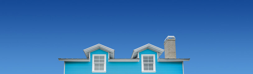 Teal colored model home on blue sky background.