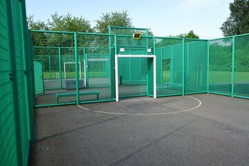 Multi-use sports court with basketball nets and football goals
