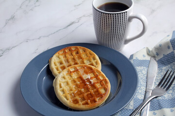 Waffles with butter and syrup, and coffee for breakfast.