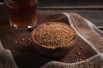 Bowl of fenugreek seeds and Egyptian fenugreek yellow tea or Methi Dana drink - obrazy, fototapety, plakaty