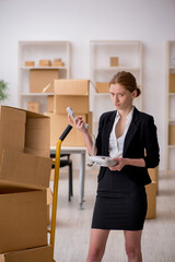 Young female professional mover doing home relocation