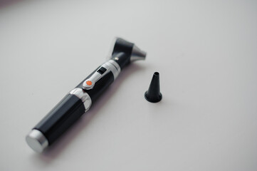 Otoscope on a white background. Instrument for examining the auricle and middle ear