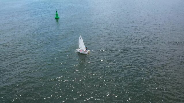 Training sailing yachts class optimist float on the sea.Yachting and sailing training. Summer sport. Aerial view top side of the blue sea and small training sailing yachts with athletes in the regatta