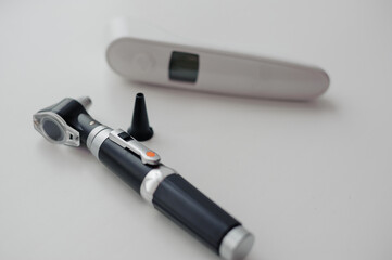 Non-contact thermometer on a white background for measuring body temperature. Otoscope on a white background, a device for examining the auricle and middle ear