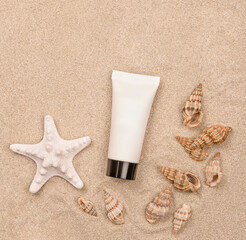 une crème solaire et des coquillages sur fond de sable