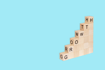 Fototapeta premium Wooden cubes block which print screen growth wording on blue background. Target of investment and business growth concept.