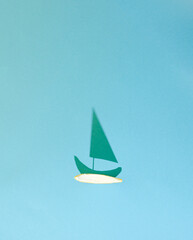 Tropical summer concept made of orange fruit peel with boat shadow in the blue water. Creative minimal summer idea. Flat lay.