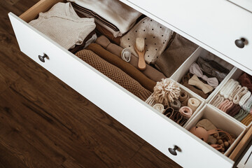 Newborn clothes and baby care accessories set in drawer shelf. Fashion Scandinavian newborn...