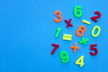 Colorful plastic digits or numbers on blue background.