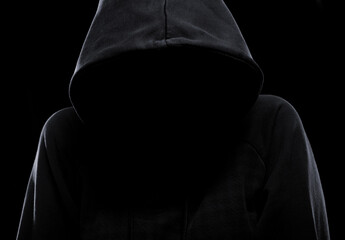 Mystery woman or man hiding face under the hood isolated on black background