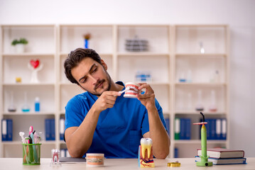 Young male dentist working in the clinic