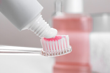 Fototapeta na wymiar Applying paste on toothbrush near mouthwash, closeup