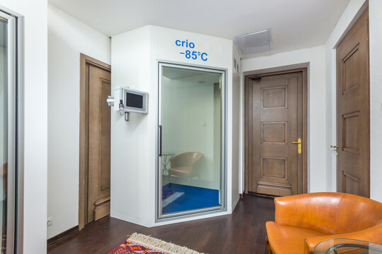 A bright room of a country house with doors and a home cryosauna.