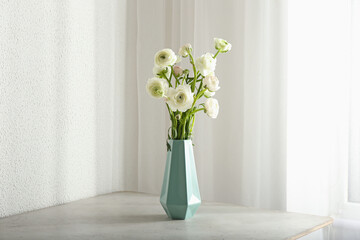 Vase with bouquet of beautiful ranunculus flowers on table