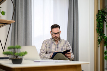 Young entrepreneur working at home taking notes