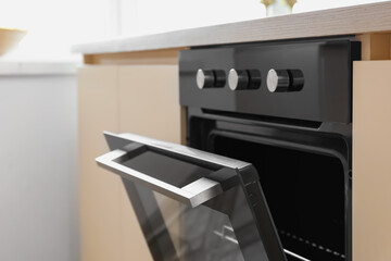Modern electric oven with knobs in kitchen, closeup