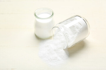 Jars with baking soda on white wooden background
