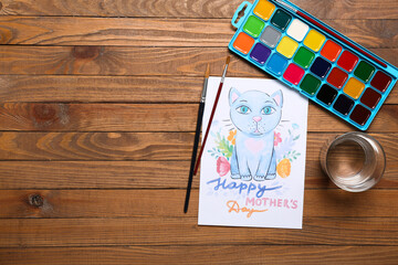 Picture with text HAPPY MOTHER'S DAY, brushes, paints and glass of water on wooden background