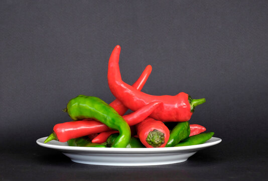 Red and green chilis stacked with black background