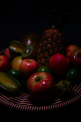 Fruit basket with star fruit, pineapple, kiwi, apple, peach, lemon