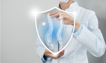 Unrecognizable female doctor holding shield and graphic virtual visualization of Spine (Vertebra)...