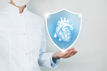 Unrecognizable female doctor holding shield and graphic virtual visualization of  Heart organ in...