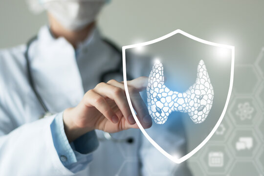 Unrecognizable female doctor holding shield and graphic virtual visualization of Thyroid Gland organ in hands.
