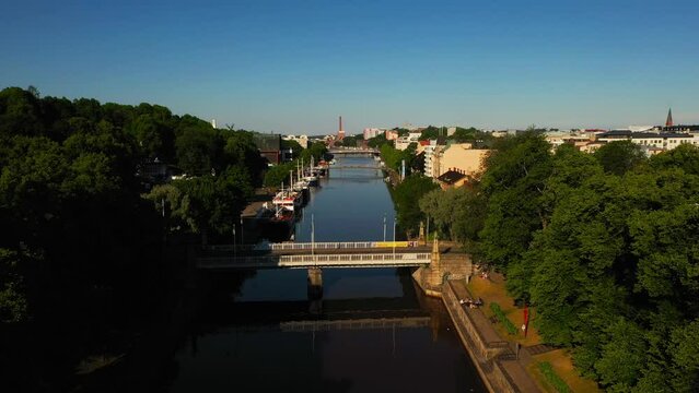 Aerial view over the Aurajoki river, warm, summer morning, in Turku, Finland - low, drone shot