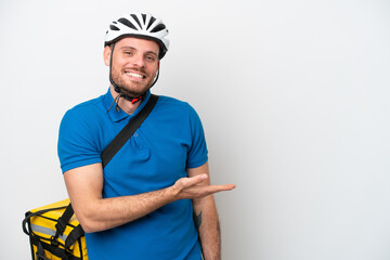 Young brazilian man with thermal backpack isolated on white background presenting an idea while looking smiling towards