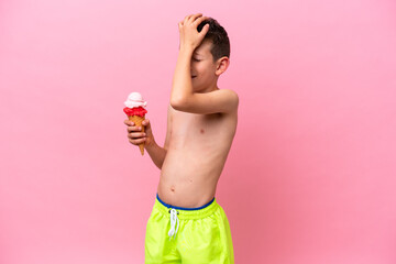 Little caucasian boy eating an ice-cream isolated on pink background has realized something and intending the solution © luismolinero