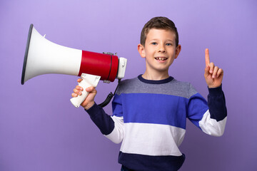 Little boy isolated on purple background holding a megaphone and pointing up a great idea