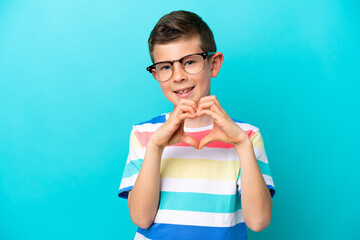 Little boy isolated on blue background With glasses making heart with hands