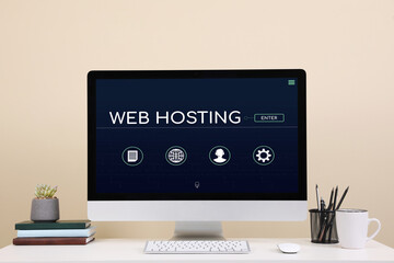 Web hosting service. Comfortable workplace with modern computer on desk near beige wall