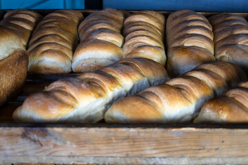 Hot loaves are laid out in trays for sale.